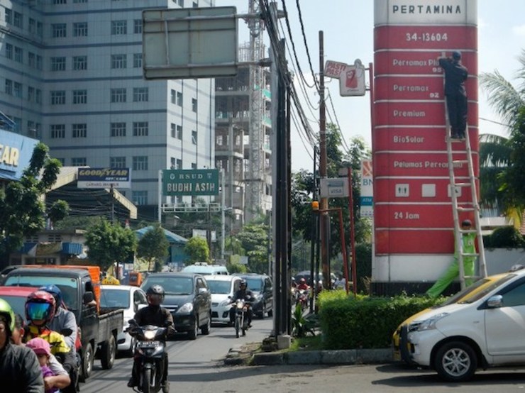 Petugas SPBU mengganti harga BBM di Jakarta. Dengan harga minyak dunia turun, pemerintah Indonesia bisa mengakomodir harga BBM disesuaikan dengan harga pasar internasional. Foto oleh Bay Ismoyo/AFP