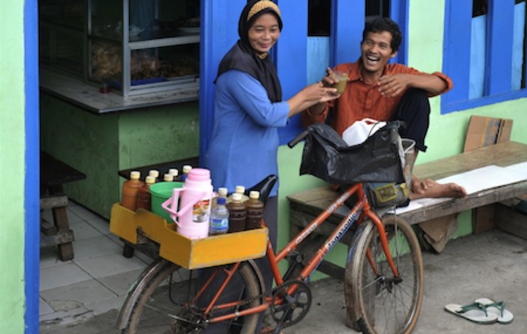 Si mbok jamu menjual dagangannya kepada seorang pembeli. Menteri Perdagangan Rachmat Gobel menganjurkan pegawai negeri sipil untuk konsumsi jamu setiap Jumat. Foto oleh Romeo Gacad/AFP